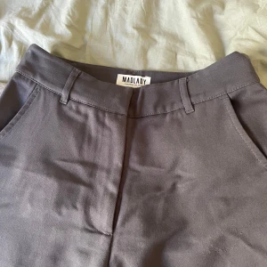 Gråa kostymbyxor från Madlady - Snygga gråa kostymbyxor från Madlady med klassisk rak passform och midja med hällor för bälte. Stl: 34/34 oanvända 