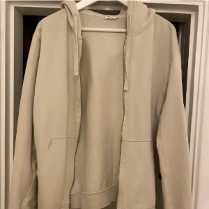 Beige zip hoodie från Filippa k - Säljer en stilren beige hoodie från Filippa K i mjuk bomull. Tröjan har dragkedja framtill, huva med snören och två fickor. Perfekt för en avslappnad look och enkel att matcha med det mesta. Nypris 1999kr från NK Stockholm 