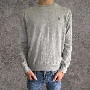 Slim tröja Polo Ralph Lauren - Snygg grå långärmad tröja från Polo Ralph Lauren i slim fit. Tillverkad i mjuk pima bomull och har den klassiska broderade loggan på bröstet. Perfekt för dig som gillar stilrena och bekväma plagg.