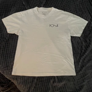 Vit t-shirt från Polar Skate Co XS - Knappt använd vit t-shirt från Polar Skate Co i storlek XS men passar S också. Framsidan har en clean Polar-logga på bröstet och baksidan har ett stort grafiskt tryck med Polar Skate Co:s ikoniska cirkellogga. Klassisk rund hals och korta ärmar. Skön bomullskvalitet.