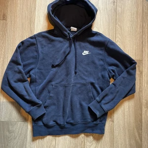 Mörkblå Nike hoodie XS - Säljer en mörkblå hoodie från Nike i storlek XS. Tröjan har huva med snörning, en stor magficka och Nike-logga broderad på bröstet. Mjuk och skön, perfekt för chill eller träning. Materialet är bomull och polyesterblandning.