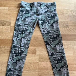 Freddy WR.UP jeans, low waist, XS - Snygga byxor från Freddy i storlek XS med grå, gröna och svarta camouflage- och fjärilsmönster.  Passar mig som normalt har S, men passar nog även XS eftersom de här sitter tightare på mig än ett par Freddy i storlek S. Tyget är lite urtvättat, men byxorna är ändå väldigt fina med sitt mönster. 