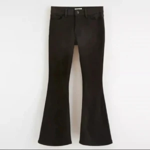 Svarta bootcut jeans - Snygga svarta jeans med bootcut-snitt som ger en schysst retrovibe. Klassisk femficksmodell med knapp och dragkedja framtill. Perfekta för dig som gillar en lite vidare siluett nertill och vill sticka ut med din stil.