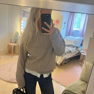 Beige stickad tröja från Vero Moda - Mysig beige stickad tröja från Vero Moda med rund halsringning och ribbade muddar. Tröjan har en avslappnad passform och är perfekt att styla med jeans eller kjol. Enkel och stilren design som funkar till många olika looks.