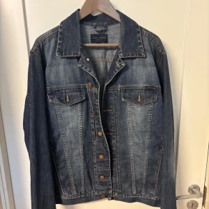 Jeansjacka - Gant Jeans - Blå jeansjacka från Gant Jeans i strl XL, används som jacka/overshirt. Jackan har bröstfickor med knappar, slitna detaljer och kontrastsömmar. Passar lika bra till hoodie som till t-shirt och skjorta.