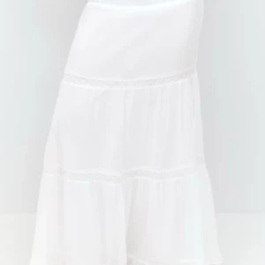 Vit långkjol i bomull med volang - Säljer en vit långkjol i mjuk bomull med volangdetaljer. Kjolen har en flowy passform och är perfekt för varma dagar. Hög midja och lätt, luftig känsla. Superfin till sneakers eller sandaler! Samma passform som på första bild bara utan spetsen