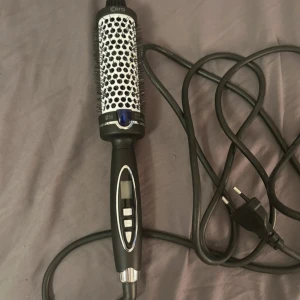 Cera värmeborste med digital display - Elektrisk värmeborste från Cera med digital display och knappar för temperaturkontroll. Rund borste med svart och vitt mönster, perfekt för att styla och skapa volym i håret. OBS. Tredje bild ej min, bara ett exempel på hur värmeborsten lockar håret.