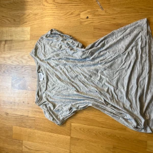 Grå t-shirt från Aware by Vero Moda - En basic grå t-shirt från Aware by Vero Moda i mjuk bomull. T-shirten har korta ärmar, rund halsringning och en avslappnad passform. Perfekt att styla med jeans eller shorts för en chill look.