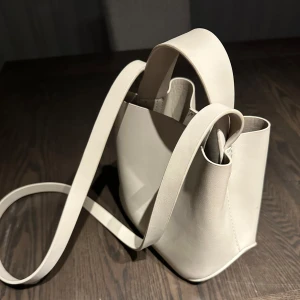 Gina tricot väska - Säljer en väska från Gina då den inte kommer till användning längre. Haft den ca ett halvår och den är sparsamt använd och inga defekter finns. den har ett fack imitten av väskan och både kort & långt band. Tror inte man kan köpa den på gina längre💞