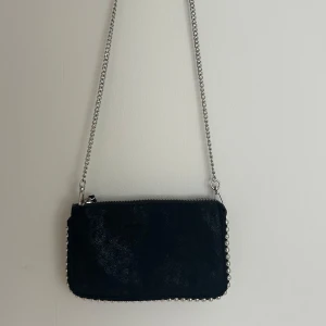 Svart axelväska med kedja - Fin svart väska med silverkedja och fina silverdetaljer! Mycket bra skick💘