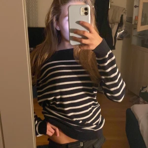 Randig svartvit stickad tröja - Säljer en svart stickad tröja med vita horisontella ränder. Tröjan har en avslappnad passform, rund halsringning och långa ärmar med ribbade muddar. Perfekt för dig som gillar klassisk stil med en modern twist.