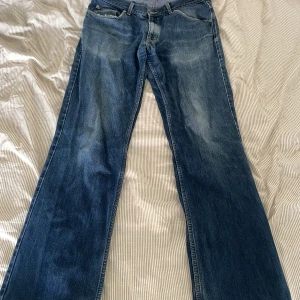 Blå bootcut jeans från Boomerang - Snygga blå jeans från Boomerang med lätt bootcut-passform. Jeansen har slitna detaljer vid bensluten och en cool tvättad look. Tillverkade i robust denim med fem fickor och läderpatch bak i midjan. Perfekta för en avslappnad stil. Finns en lagning i grenen. Men inget som syns vid användning 36/34 men passar mig som är 34/34
