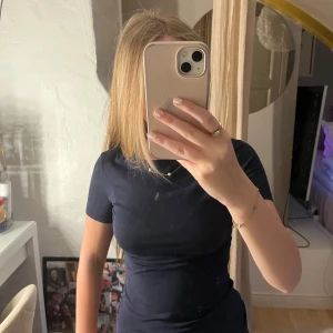 Svart t-shirt från Intimissimi - En svart, tight t-shirt från Intimissimi i mjuk Supima-bomull. Klassisk rund halsringning och korta ärmar, perfekt basic-plagg att ha i garderoben. Snygg passform som sitter nära kroppen och funkar till allt.