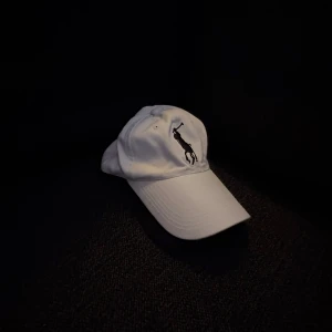 Vit keps från Polo Ralph Lauren - Vit keps från Polo Ralph Lauren men lite äldre. Kontakta för fler bilder eller frågor.