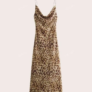 Leopardmönstrad långklänning med tunna band från Zara - Snygg långklänning med leopardmönster och tunna axelband. Klänningen har en lös passform och ett mjukt, glansigt material som ger en lyxig känsla. Perfekt för dig som vill sticka ut med ett djurmönster och en trendig siluett. Från Zara, lånade bilder på en liknande klänning