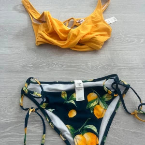 Gul och mörkblå bikini med citronmönster - Superfin bikini i storlek S med gul topp och mörkblå trosor med citronmönster. Trosorna har knyt i sidorna och toppen har smala axelband.🙌🍋🍋