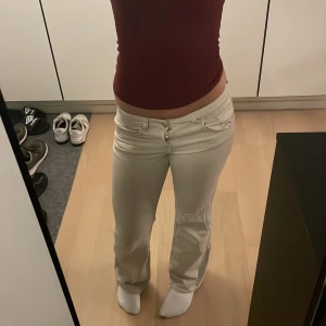 Beiga bootcut byxor med låg midja - Säljer ett par snygga beiga byxor med bootcut och låg midja. De har klassisk femficksdesign, dragkedja och knapp framtill. Materialet känns mjukt och perfekt till hösten😍Innebenslängd = 76,5 Midjans omkrets = 72 cm 