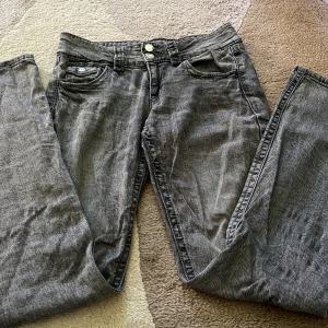 Gråa jeans  - Säljer ett par grå jeans från Gina Tricot i storlek 158. Klassisk femficksmodell med raka ben och normal passform. Jeansen har en snygg tvättad look och stängs med dragkedja och knapp. Jeansen är snubblig använda men väldigt sköna