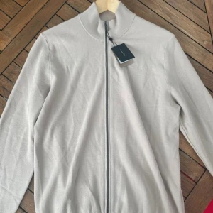 Beige kofta från Massimo Dutti - Stilren beige kofta från Massimo Dutti. Helt ny och aldrig använd bara provad. Storlek M men kan passa mindre L.