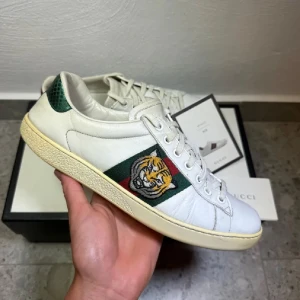 Gucci Ace Tiger  - Gucci Ace Tiger || Storlek 40 (UK 6) || Skorna är i bra skick men defekter förekommer (se bilder) || Mitt pris 1899kr || Box och kort medföljer vid köp ||Tveka inte på att höra av dig vid frågor eller funderingar 
