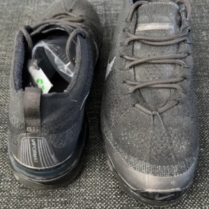 Nike Vapormax svarta sneakers - Svarta Nike Vapormax sneakers med stickad ovandel och genomskinlig, bubblig sula. Swoosh-logga i grått på sidan och snörning framtill. Lätta och flexibla med modern design. Skriv privat för mer bilder samt frågor🤝