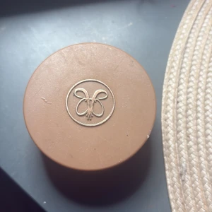 Anastasia Beverly Hills Cream Bronzer Caramel - Krämig bronzer i färgen Caramel från Anastasia Beverly Hills. Kommer i en rund burk med bronsfärgat lock och guldig logga. Ger en varm, solkysst look och är lätt att blenda ut på huden. Vegansk och cruelty free formula.