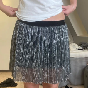Silvrig glittrig fest kjol - Säljer denhör silvriga glittriga kjolen. Passar perfekt till men festliga tillfällen tex nyår. Den är ifrån Lindex kids. Storlek 134/149, 8-10 år men skulle gissa att den passar både yngre och äldre barn.