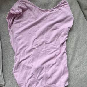 Ljusrosa topp från Gina Tricot - Säljer en ljusrosa topp från Gina Tricot. Toppen är ärmlös och öppen i ryggen och har en enkel design som passar perfekt till sommaren. Materialet är mjukt och bekvämt. 