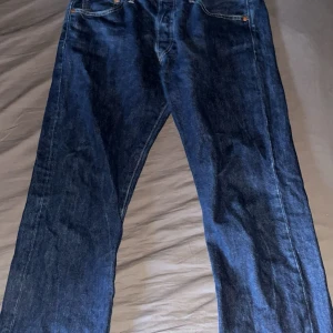 Levis 501 jeans - Säljer ett par klassiska Levis 501 jeans i mörkblå denim. De har en rak passform och är tillverkade i slitstarkt jeanstyg. Perfekta för en tidlös stil. Knappt använda