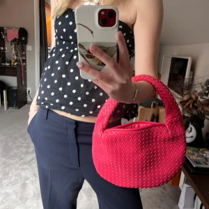 Rosa flätad handväska - Snygg rosa handväska med flätat mönster och dragkedja. Perfekt för att ge en färgklick till din outfit. Den har ett bekvämt handtag och är lätt att bära med sig.