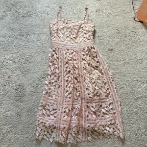 Rosa spetsklänning - Säljer en söt rosa klänning med spetsdetaljer och smala axelband. Perfekt för sommarens fester. 