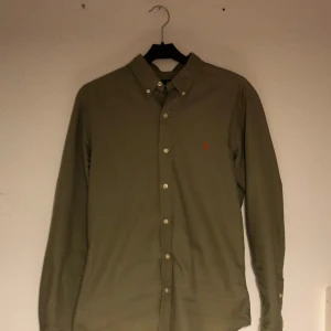 Grön skjorta från Polo Ralph Lauren stl S - Snygg grön skjorta från Polo Ralph Lauren i slim fit. Skjortan har långa ärmar och knappar framtill. Den är broderad med det klassiska logotypen i orange på bröstet. Perfekt för en stilren look. Pris kan diskuteras vid snabb affär bara att skriva för frågor Mvh luxury finds💸🌟