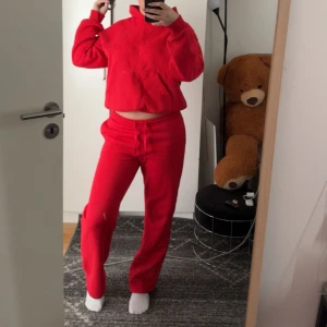 Rött sett - Säljer en röd hoodie och byxor med en bekväm och avslappnad passform. Hoodien har en klassisk design med huva och långa ärmar. Perfekt för en casual look eller mysiga dagar hemma. Limit edition från Gina Tricot och använd endast en gång. 