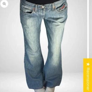 Lågmidjade jeans - Säljer ett par klassiska blå jeans från Aline. De har en normal passform med raka ben och är tillverkade i 100% bomull. Perfekta för en avslappnad stil. Midjemått är 42 cm och innerbenslängd 82 cm.