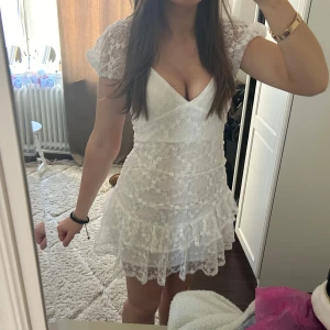 Vit spetsklänning Hello Molly - Säljer en söt vit spetsklänning med volanger och v-ringad design. Perfekt för studenten ❤️❤️prislappen kvar, köpte för 1200