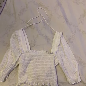 Vit blus från H&M - Säljer en söt vit blus från H&M, perfekt för vår och sommar. Den är endast använd 2-3 gånger.