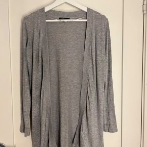Grå kofta från Ullared tror jag - Säljer en stilren grå kofta från Ullared . Den är långärmad och har en öppen design utan knappar. Perfekt för lager-på-lager och passar till många olika outfits. Koftan är tillverkad i ett mjukt material som känns skönt mot huden.