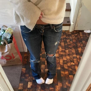 Lee jeans - Skitsnygga lågmidjade jeans med slitningar från Lee i storlek 26/33 och modell bootcut. Jag är 164 ish och har relativt lång ben i relation till överkropp och dom är möjligtvis lite långa på mig, kan skicka mått om så önskas! Dragkedjan är sönder vilket syns på en av bilderna, men kanske kan lagas vet ej. Vet därför inte vad som är rimligt pris men kom gärna med egna förslag! Har lite fler bilder som jag kan skicka!💗 