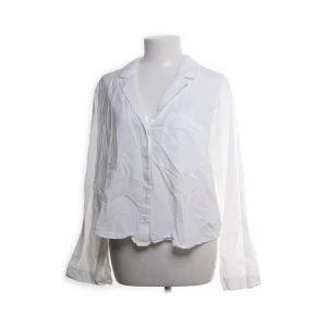 Vit skjorta från Weekday - Säljer en stilren vit skjorta från Weekday i storlek L. Skulle säga att den passar S-M. en blandning av bomull och viskos. 