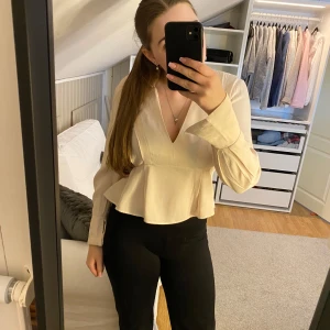 Vit blus med volangdetalj - Säljer en stilren vit blus med v-ringning och volangdetalj i midjan. Blusen har långa ärmar💕Öppen för pris förslag🩷