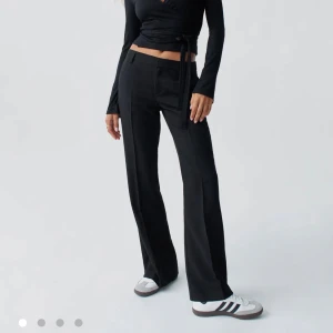 Svarta kostymbyxor med wide fit - Snygga svarta kostymbyxor med raka, vida ben. Klassisk look med pressveck och diskreta fickor. Endast testade, aldrig använda. Lappen sitter kvar. 