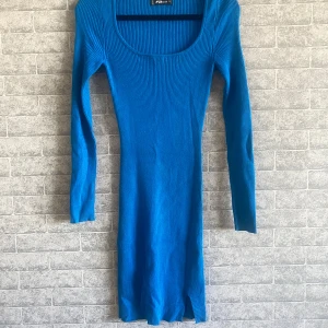 Blå ribbad långärmad klänning - Snygg blå ribbad klänning från Amisu med lång ärm. Klänningen är figurnära och har en liten slits nertill. Perfekt för dig som gillar en enkel men stilren look. Knappt använd 