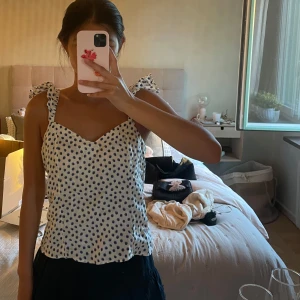 Prickig vit linnetopp med volangband - Supersöt vit linnetopp med svarta prickar och volangiga axelband💗💗