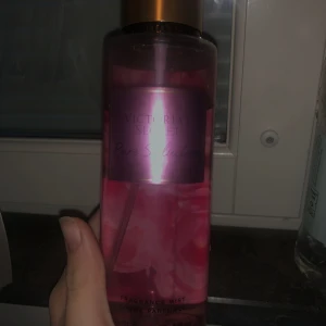 Victoria's Secret Pure Seduction mist - Fräsch och fruktig body mist från Victoria's Secret i doften Pure Seduction. Flaskan är genomskinlig med rosa vätska och har ett guldigt lock. Doftnoter av plommon och fresia ger en söt och blommig känsla. Perfekt för dig som gillar en feminin och ungdomlig doft.