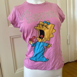 Simpsons rolig t-shirt  - Rolig t-shirt med Simpsons-tryck med Rhinestones. Skrikande maggie och text med Life Sucks. några rhinestones har släppt men i övrigt bra skick. 🌷 