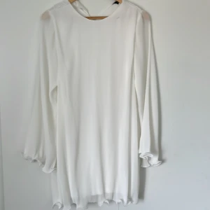 Vit långärmad klänning från Gina Tricot - Superfin vit klänning från Gina Tricot i storlek 36. Långärmad modell med lätt rynkade ärmslut och vågig kant nertill. Tunn och flowy känsla, perfekt för en fräsch look. Enkel och stilren design som är lätt att matcha.