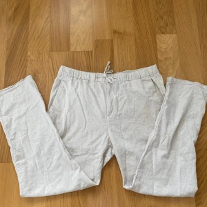 Beiga linnebyxor från H&M med snörning - Snygga beiga linnebyxor från H&M i regular fit. Byxorna har elastisk midja med snörning, raka ben och sidfickor samt en bakficka. Perfekta för chill dagar eller när du vill ha en avslappnad stil. Nypris: 399 mitt pris 149