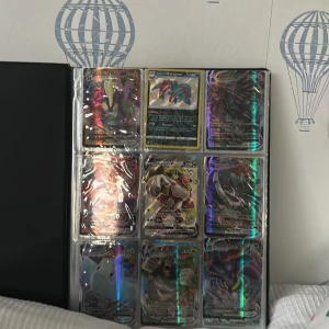 Pokémonkort Samlarpärm - En snygg samlarpärm fylld med glittrande och sällsynta Pokémonkort, inklusive VMAX, GX och EX-kort. Perfekt för dig som älskar Pokémon och vill utöka din samling med coola och färgstarka kort. Passar både nya och erfarna samlare!