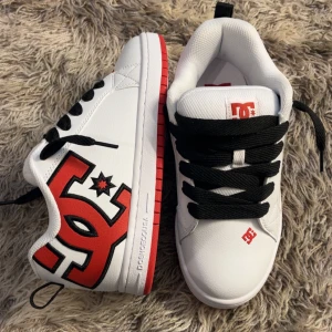 DC Shoes vita sneakers med röd logga - Fräscha vita sneakers från DC shoes. kommer i orginal förpackning.