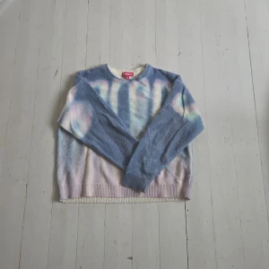 Supreme Blurred Logo Sweater blå S - Supreme Blurred Logo Sweater i blått med suddigt logomönster över hela framsidan. Tröjan har rund halsringning, ribbade muddar och en mjuk, stickad känsla. Färgskiftningar i blått, vitt och pastellrosa ger en unik vibe. Perfekt för dig som vill sticka ut. Ny pris runt 7000